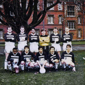 Team posing behind Jesus College